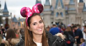 Mulher com orelha da Disney em frente ao castelo do Magic Kingdom