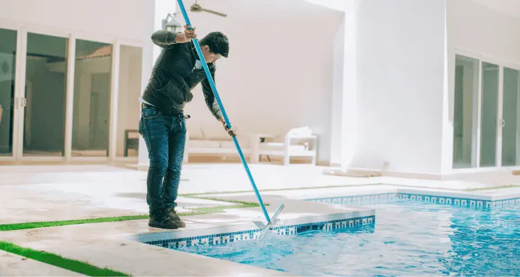 homem limpando piscina