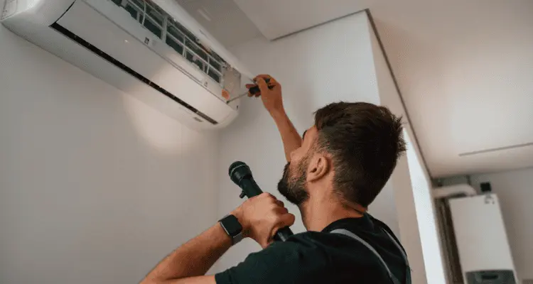 Homem arrumando ar condicionado