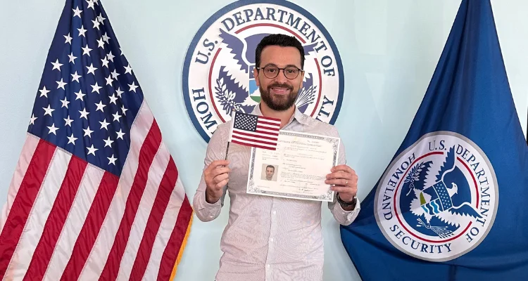 Homem com o certificado de naturalização na mão no dia da cerimônia