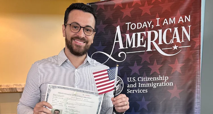 Homem com o certificado de naturalização na mão no dia da cerimônia