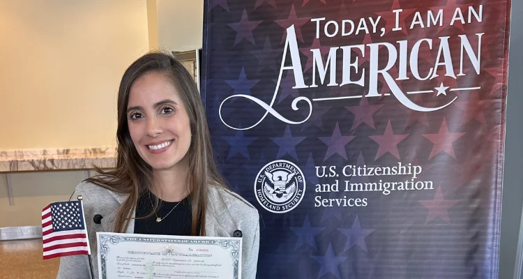 Mulher com o certificado de naturalização na mão no dia da cerimônia