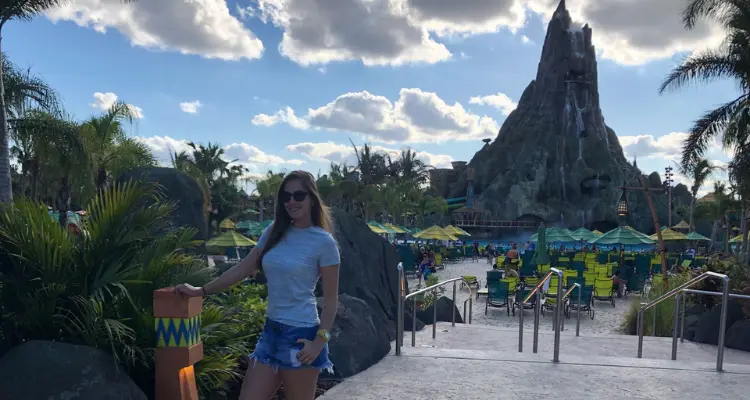 Mulher no Volcano Bay, tirando foto em frente do vulcao