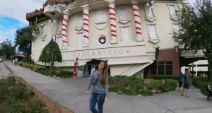 Mulher em frente a casa de ponta cabeça em Orlando