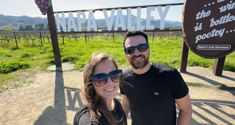 Casal na frente do letreiro um vinhedo em Napa Valley